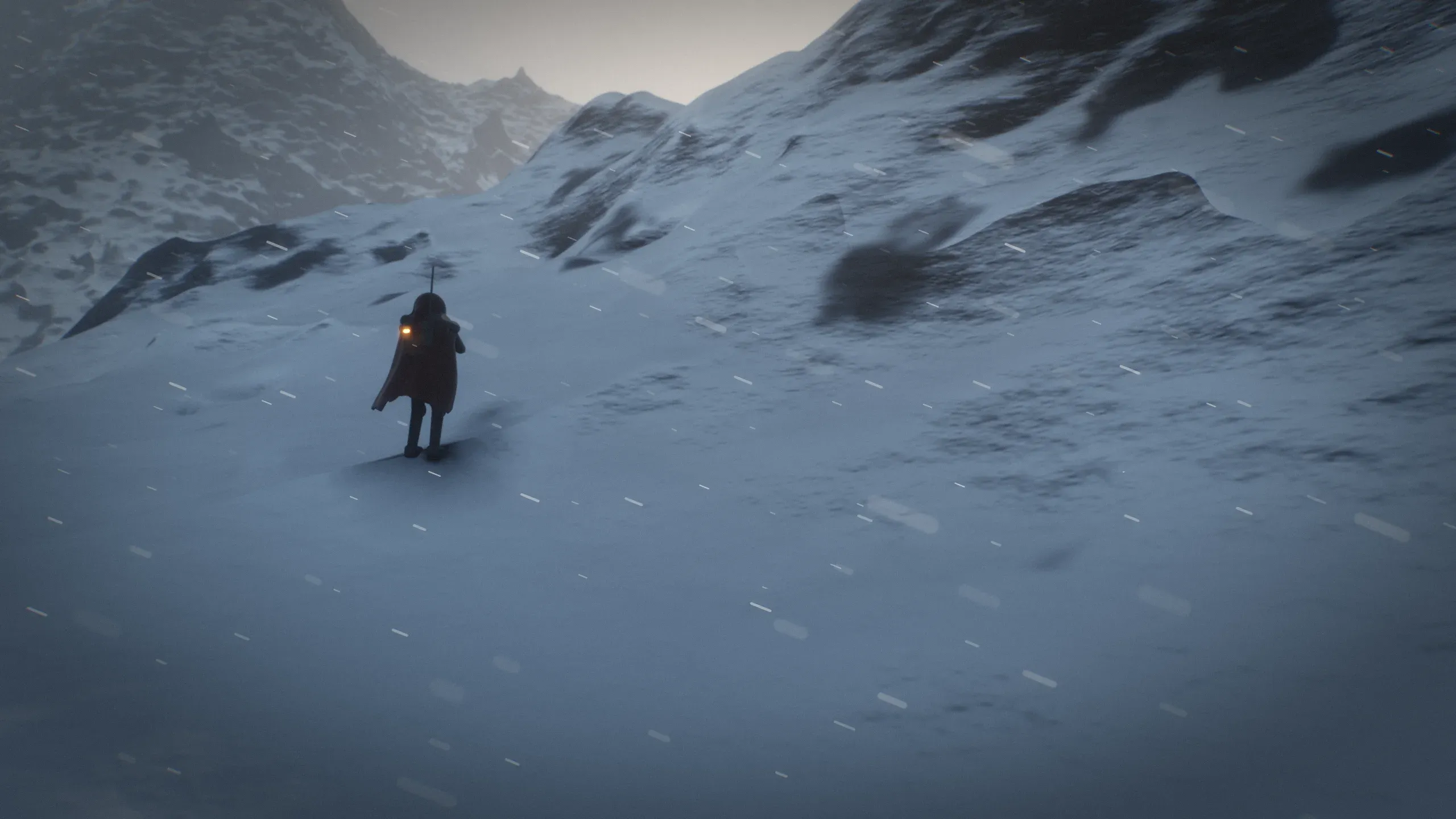 A hooded Rogue crosses a wind-blown snowfield below a mountain ridge